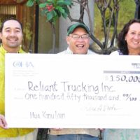 Photo: Reliant Trucking owners holding a check
